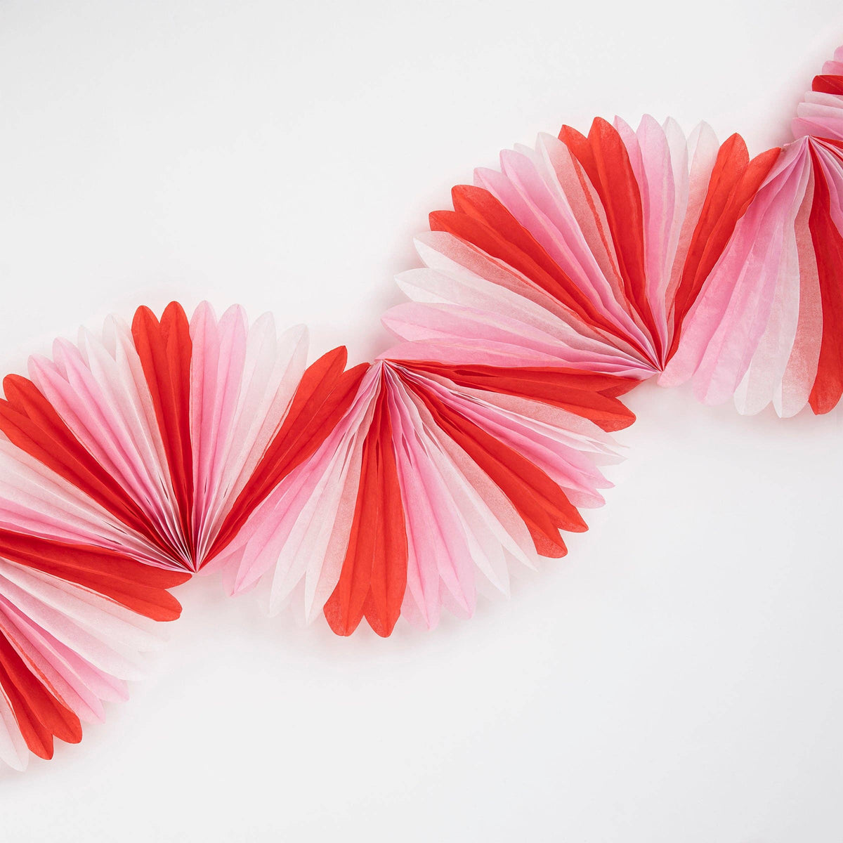 Decorative paper fans in red and pink on a white background