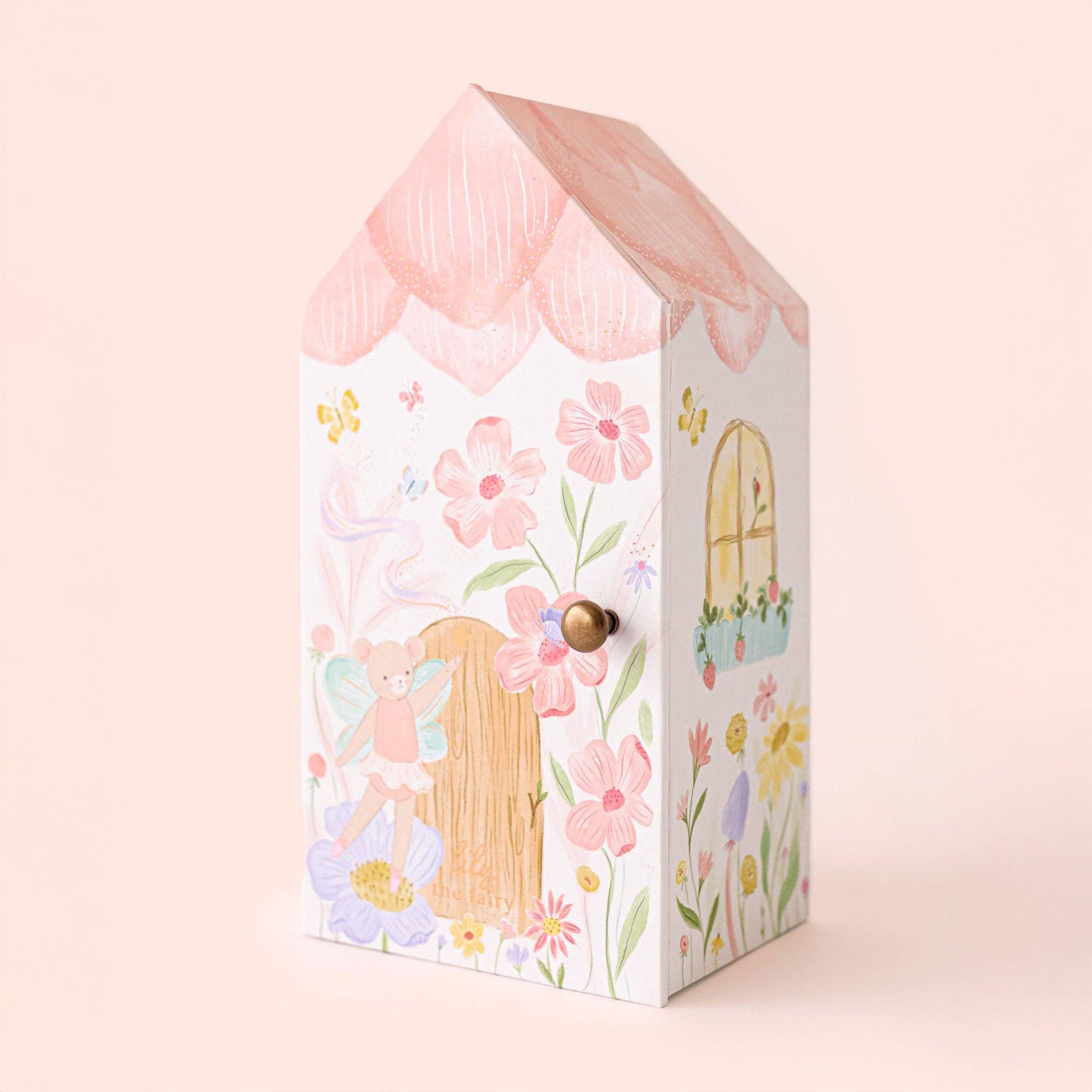 Decorative box with fairy design and floral elements on a light pink background