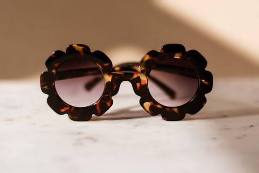 Toddler and kid-sized sunglasses in neutral color featuring a daisy shape design.