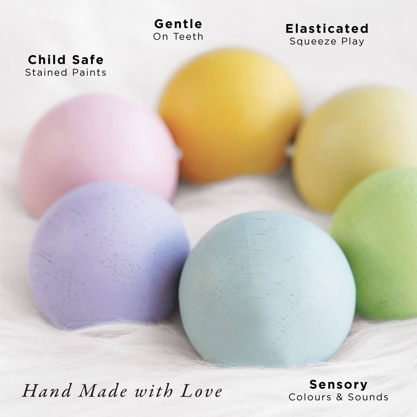Colorful wooden teething beads on a white background with text describing their features. "Child safe Stained paints, gentle on teeth, elasticated squeeze play, hand made with love, sensory color and sounds"