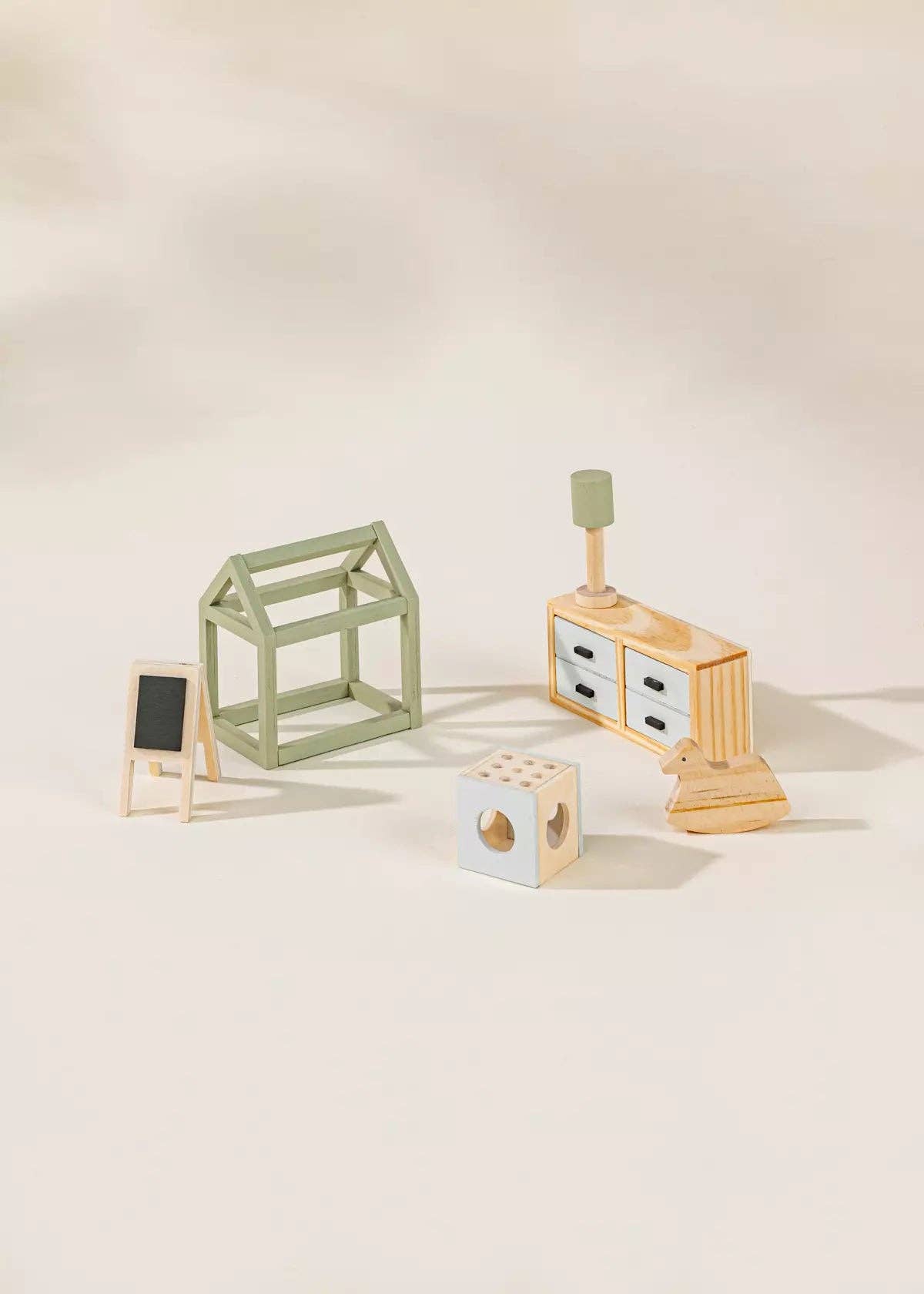 Set of wooden toys including a house bed, desk, and blocks on a light background