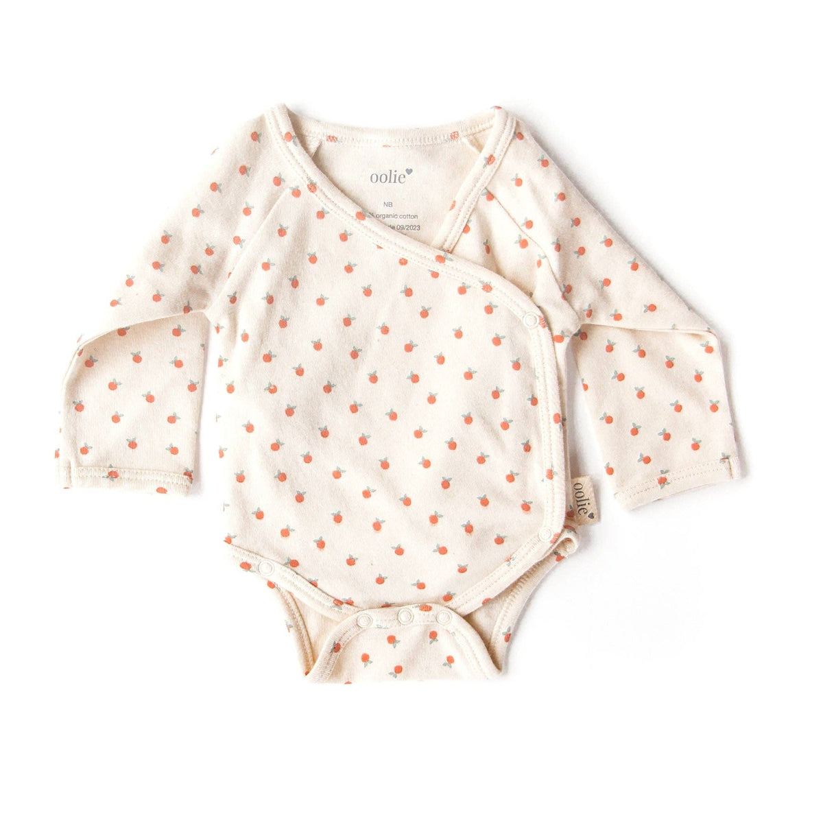 Baby onesie with long sleeves and orange polka dots on a white background