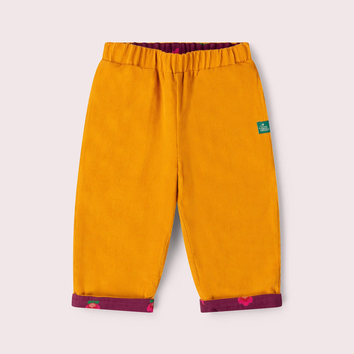Mustard corduroy side of reversible trousers with purple floral turn-ups and an elastic waist.