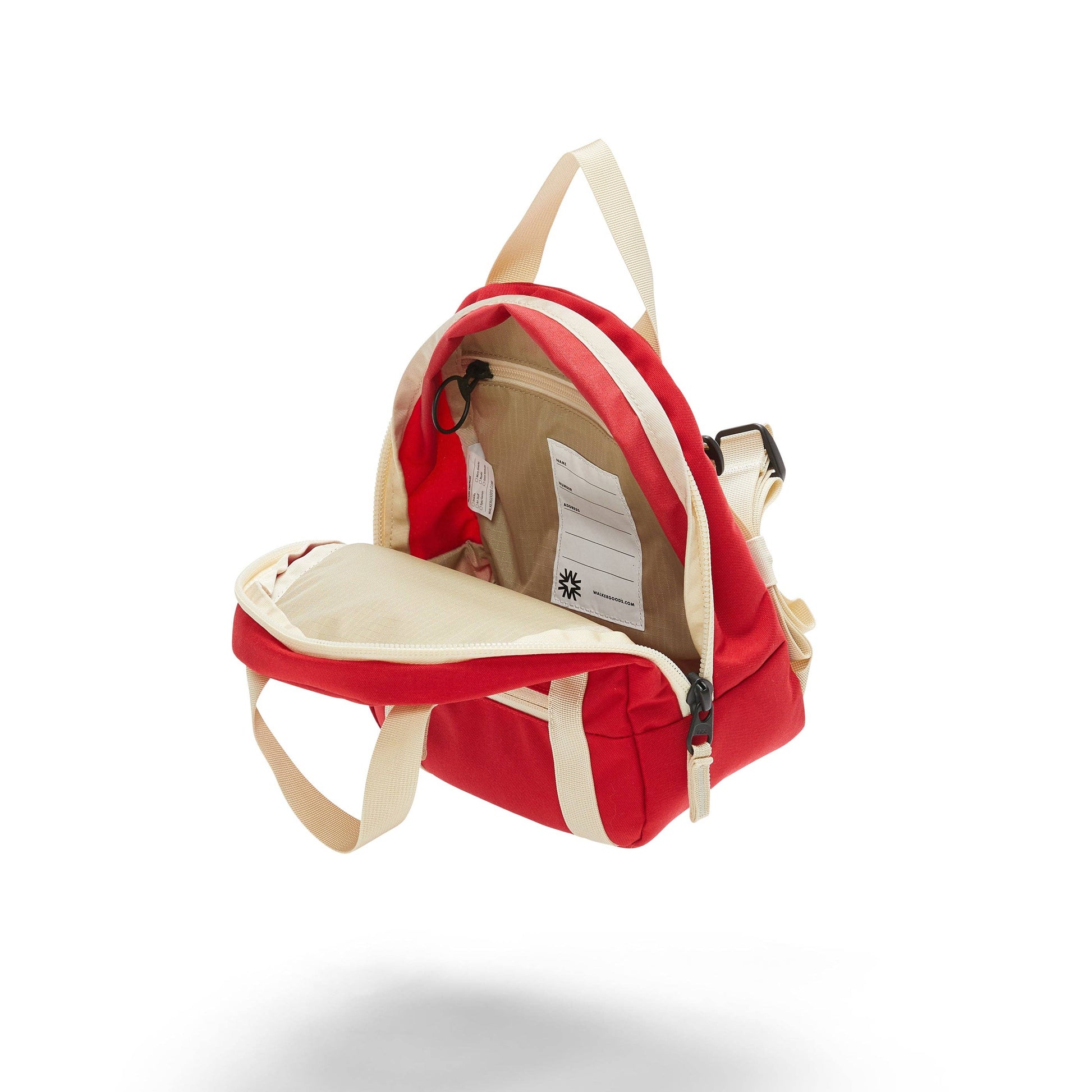 red kids backpack unzipped so the inside is shown