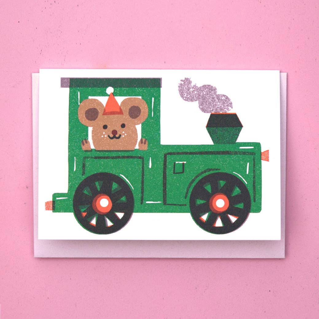 Card with a bear driving a green train on a pink background