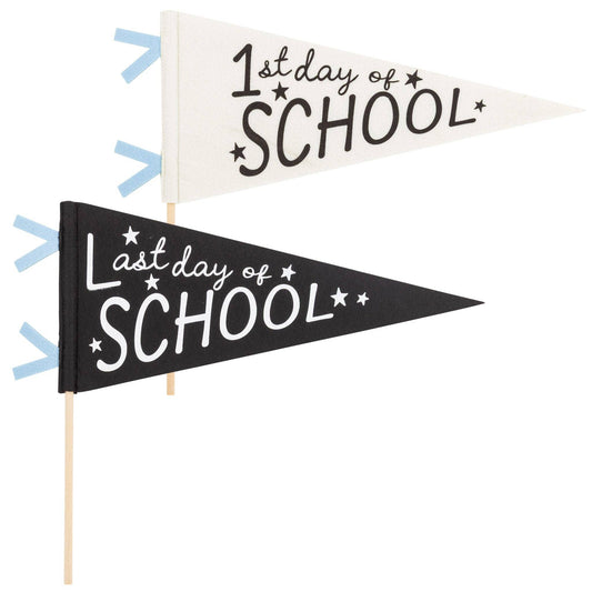 Two pennants on a white background, one black one that says "last day of school" and one white one that says "first day of school"
