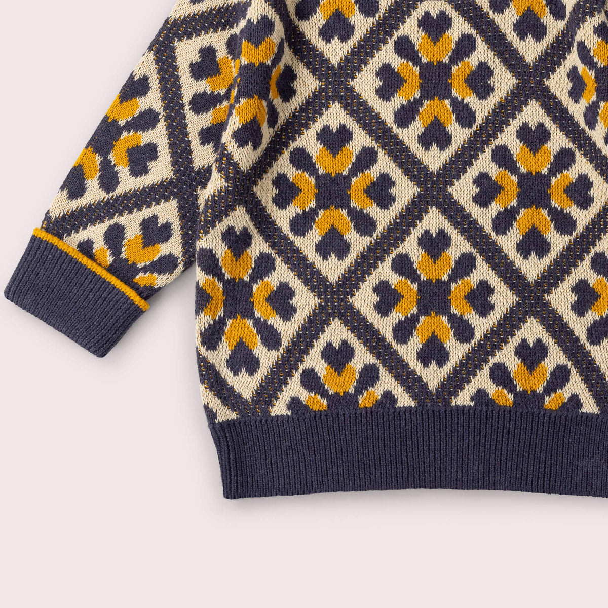 Detail of the diamond pattern, ribbed cuff and hem on a knitted jumper.