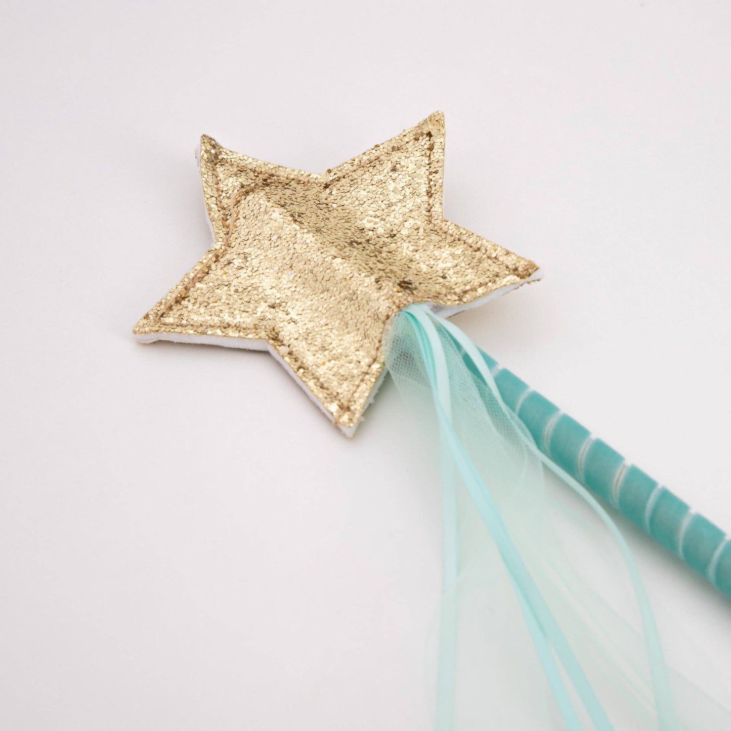 Gold star wand with a blue ribbon on a light gray background