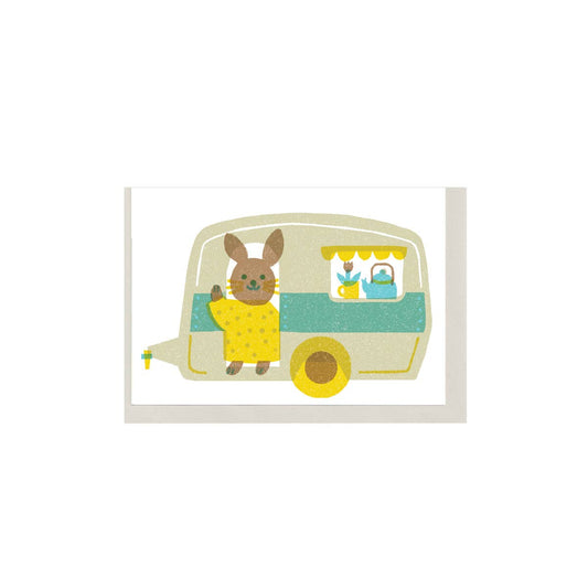 Small card with illustration of a rabbit character with a camper on a white background