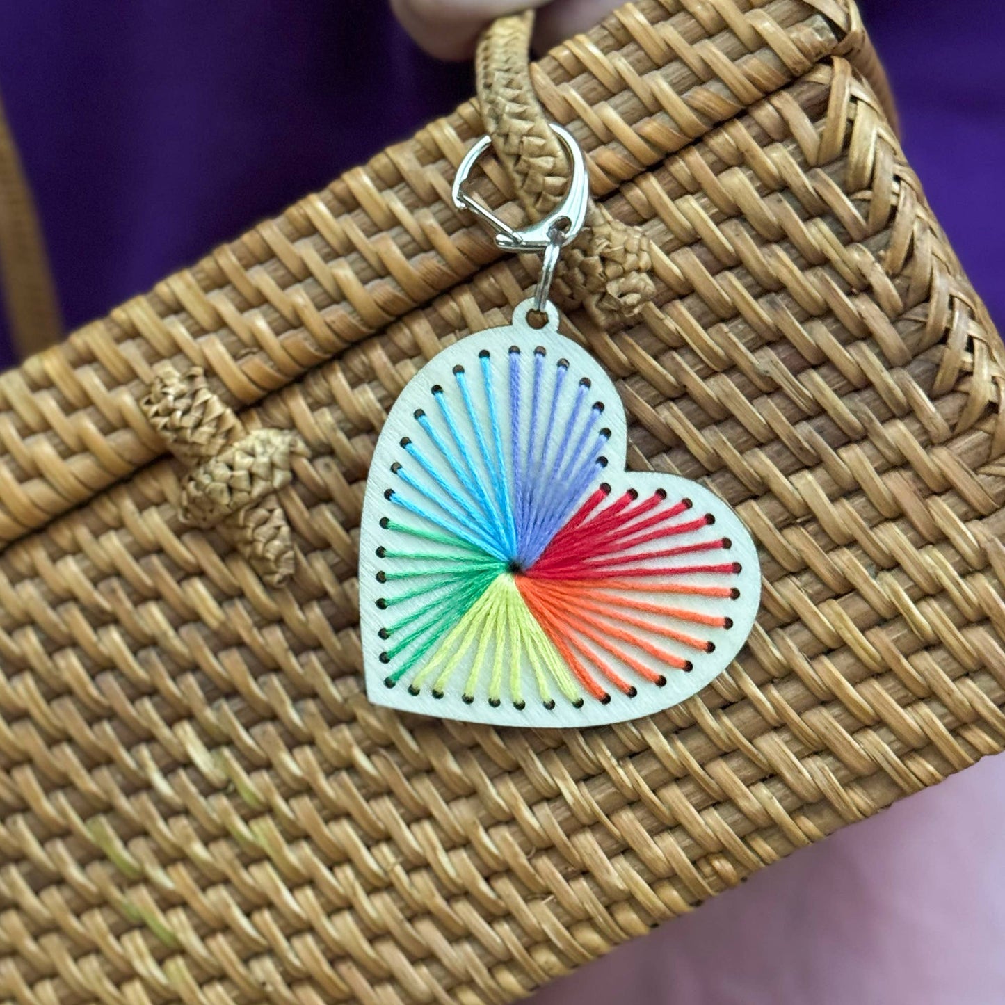 Colorful heart-shaped keychain on a woven surface