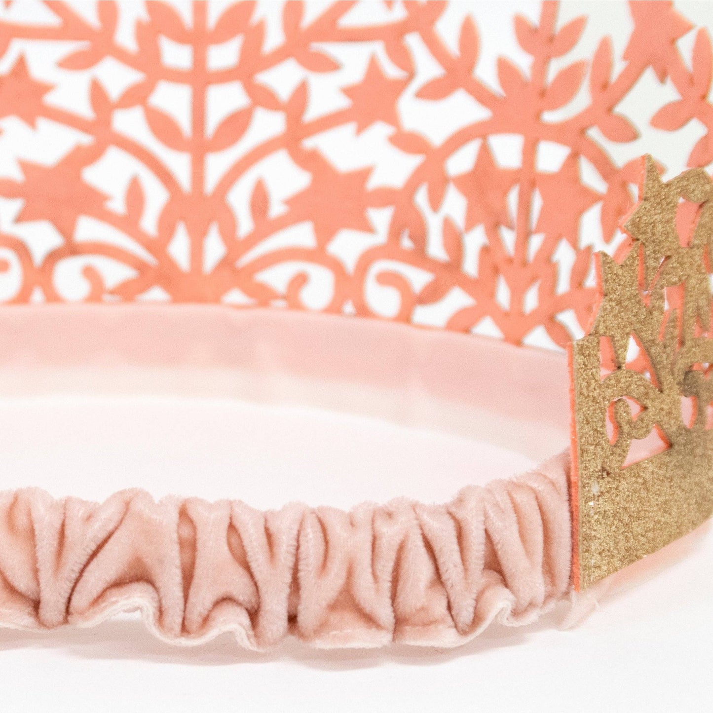 Pink headband with gold accents on a white background