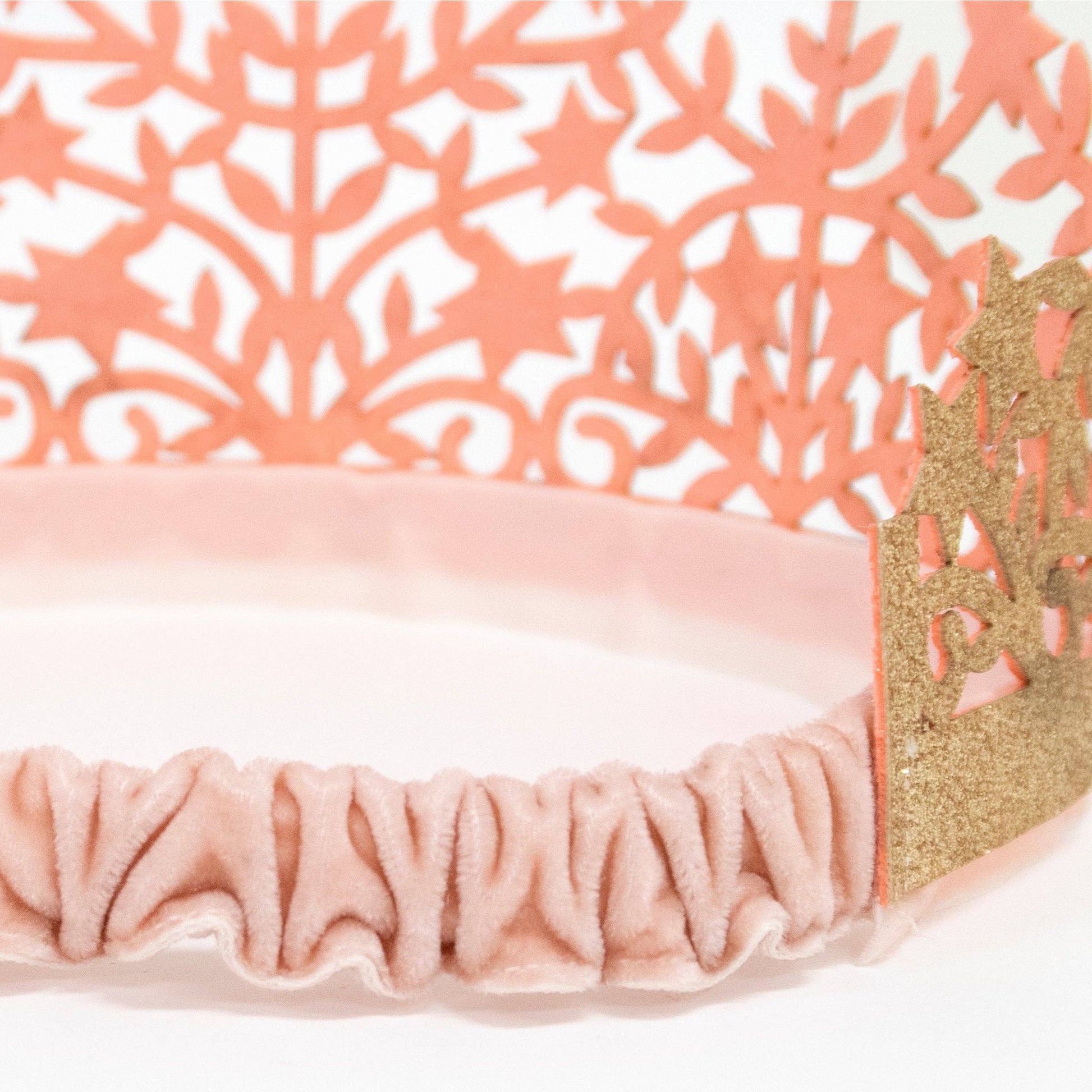Pink headband with gold accents on a white background