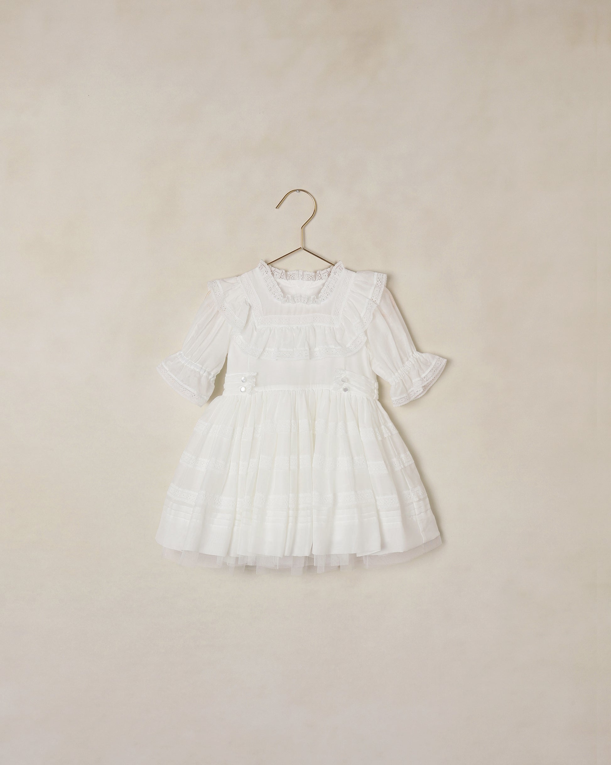 White dress on a hanger against a beige background