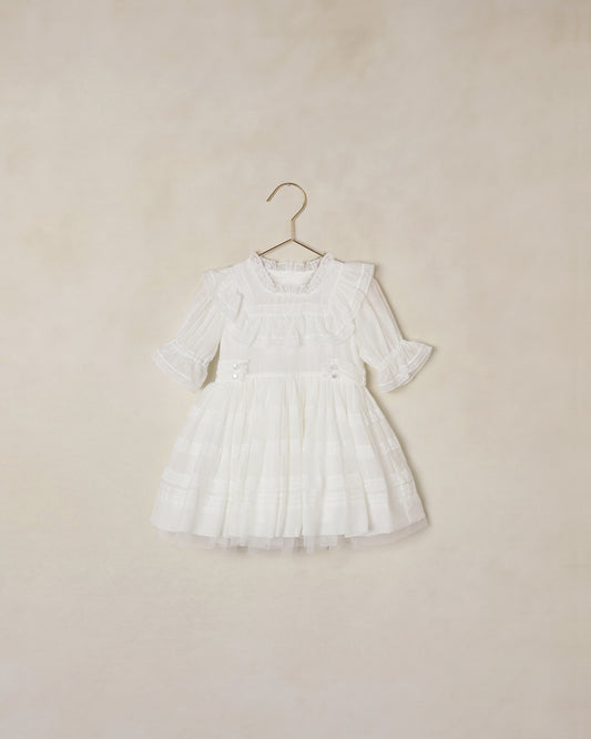 White dress on a hanger against a beige background