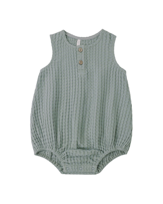 Green baby romper with button details on a white background
