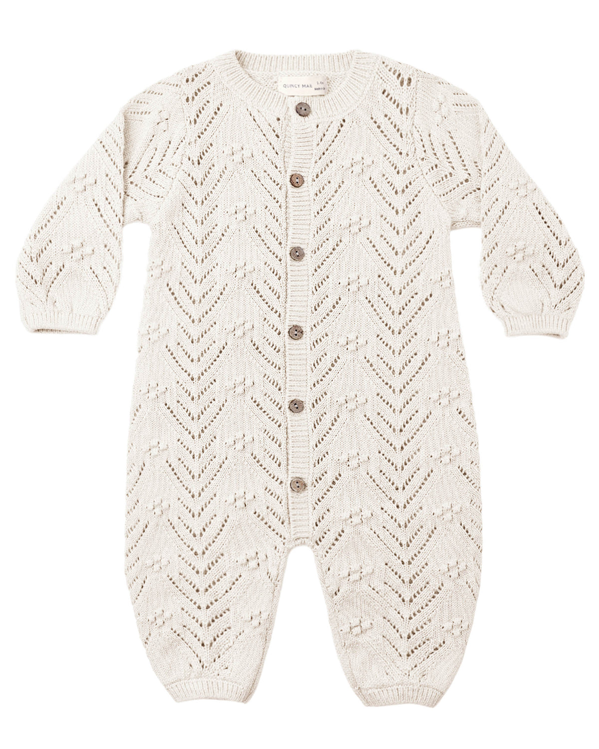 crocheted ivory baby romper with buttons down the front, shown on a white background