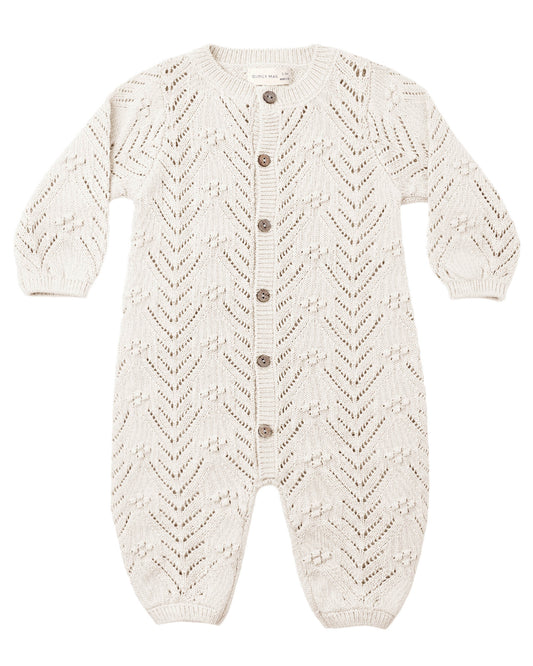 crocheted ivory baby romper with buttons down the front, shown on a white background