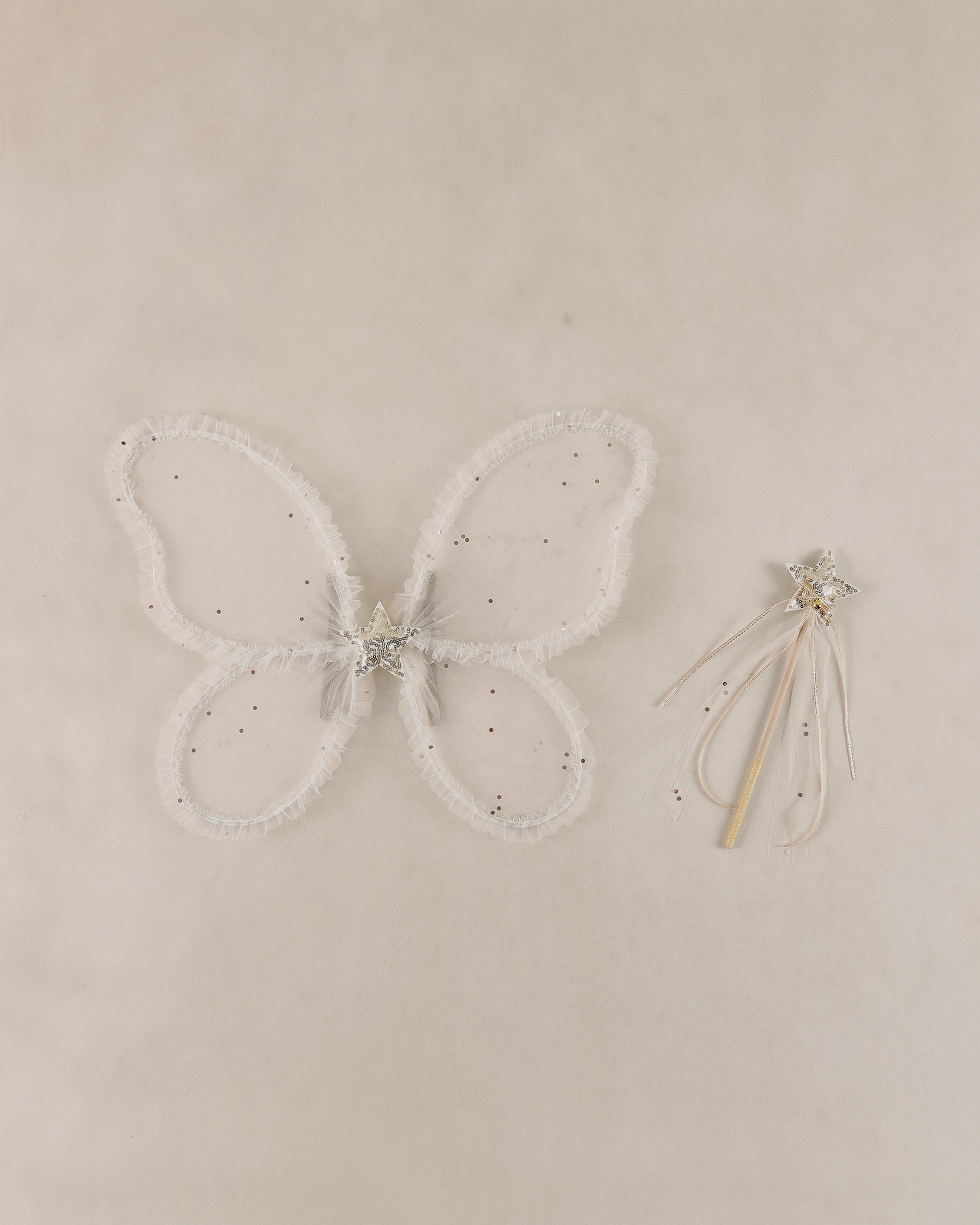 Butterfly wings with a wand on a beige background