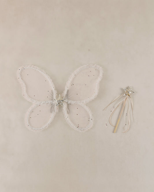Butterfly wings with a wand on a beige background