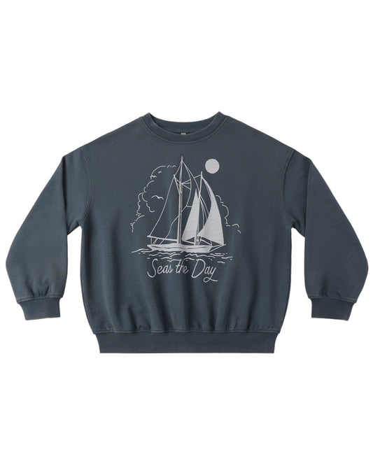 Navy blue sweatshirt with sailboat graphic and 'Seas the Day' text on a white background