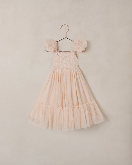 Blush pink dress with ruffled sleeves on a hanger against a beige background