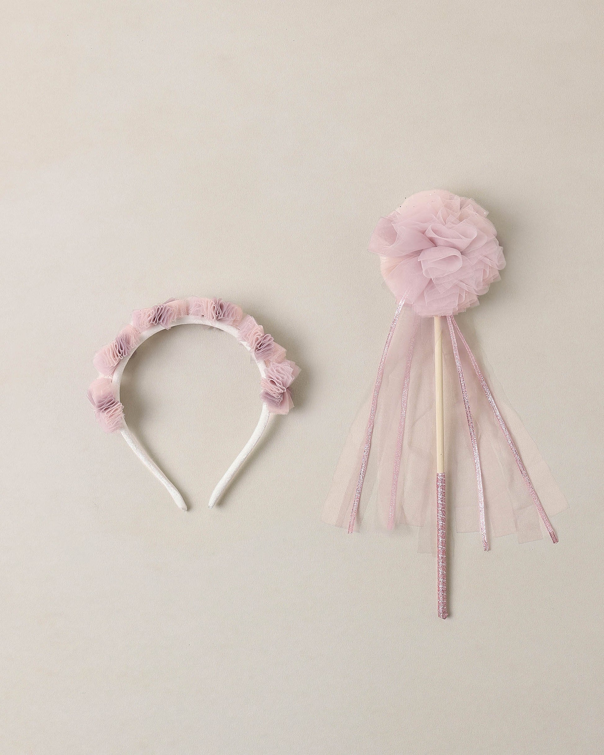 Pink tulle headband and matching wand on a beige background