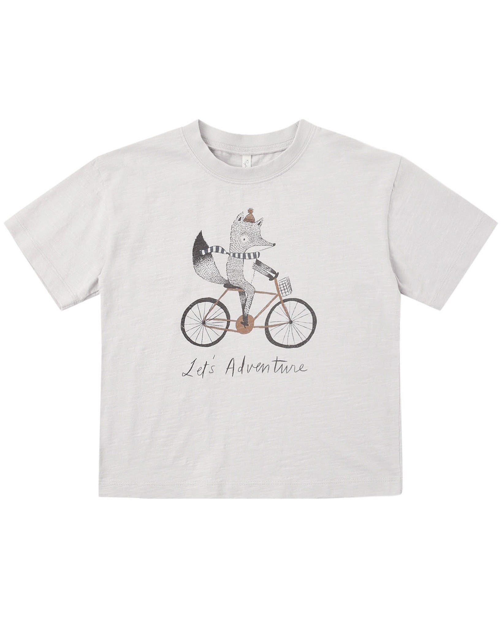 White t-shirt with a graphic of a fox riding a bicycle and 'Life is an Adventure' text on a white background.